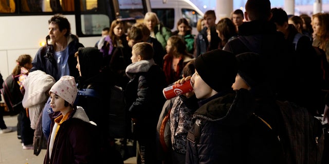 Ukrainian orphans are seen during a stopover in Warsaw as they are en route to the UK, in Warsaw, Poland, on Monday, March 21, 2022. A UK-based group Dnipro Kids is helping the nearly 50 children get refugee in the UK until the Russia's war against Ukraine is over. They were supposed to fly on Monday but got stuck in Warsaw due to a paperwork issue. 