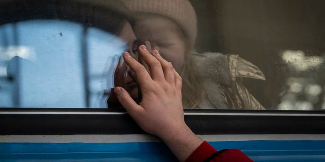 Displaced Ukrainians on a Poland-bound train bid farewell in Lviv, western Ukraine, Tuesday, March 22, 2022. The UN refugee agency says more than 3.5 million people have fled Ukraine since Russia's invasion, passing another milestone in an exodus that has led to Europe's worst refugee crisis since World War II. 