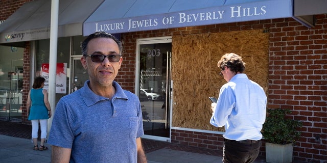 Owner Peter Sedghi stands on the street in front of his boarded up shop, Luxury Jewels of Beverly Hills in Beverly Hills, Calif. Sedghi said he was in his back office when he heard what sounded like gunshots during a brazen smash-and-grab robbery.