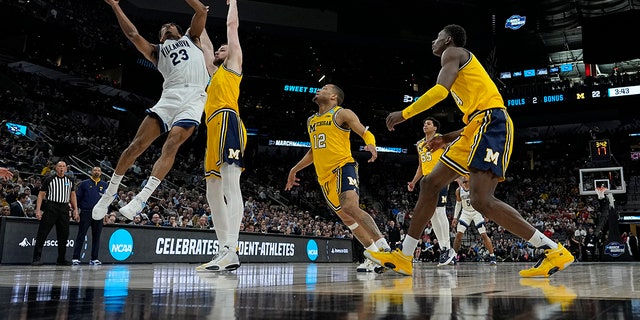 Villanova forward Jermaine Samuels shoots over Michigan center Hunter Dickinson during the first half of a college basketball game in the Sweet 16 round of the NCAA tournament on Thursday, March 24, 2022, in San Antonio.