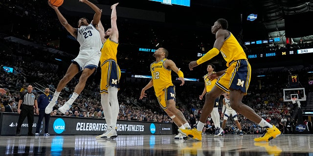 Villanova forward Jermaine Samuels shoots over Michigan center Hunter Dickinson during the first half of a college basketball game in the Sweet 16 round of the NCAA tournament on Thursday, March 24, 2022, in San Antonio.