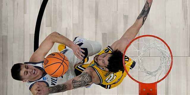 Villanova guard Collin Gillespie shoots over Michigan forward Brandon Johns Jr. during the second half of a college basketball game in the Sweet 16 round of the NCAA tournament on Thursday, March 24, 2022, in San Antonio.