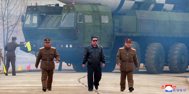 In this photo distributed by the North Korean government, North Korean leader Kim Jong Un, center, walks around what it says is a Hwasong-17 intercontinental ballistic missile (ICBM) on the launcher at an undisclosed location in North Korea March 24, 2022. 