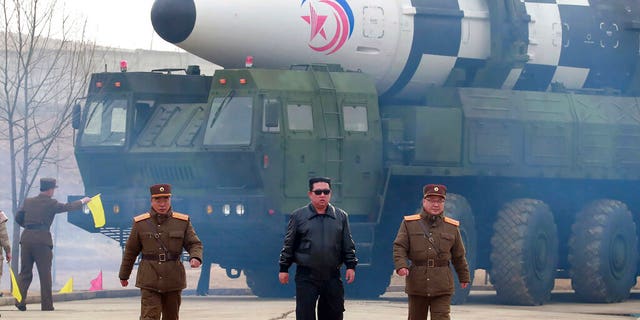 In this photo distributed by the North Korean government, North Korean leader Kim Jong Un, center, walks around what it says is a Hwasong-17 intercontinental ballistic missile (ICBM) on the launcher at an undisclosed location in North Korea March 24, 2022. 