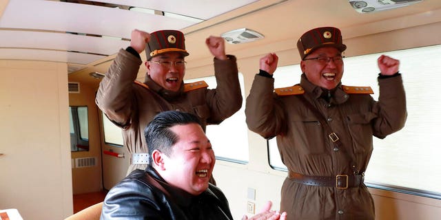 Op deze foto, verspreid door de Noord-Koreaanse regering, klapt de Noord-Koreaanse leider Kim Jong Un tijdens een testvuur van wat naar eigen zeggen een Hwasong-17 intercontinentale ballistische raket (ICBM) was, op een niet nader genoemde locatie in Noord-Korea op 24 maart 2022 .