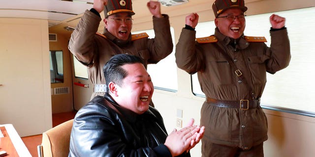 In this photo released by the North Korean government, North Korean leader Kim Jong Un, front, claps his hands during a test fire of the Hwasong-17 intercontinental ballistic missile (ICBM) at an undisclosed location in North Korea on March 24.  , 2022 (Korea Central News Agency/Korea News Service via AP)