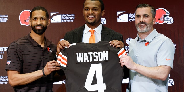 O gerente geral do Cleveland Browns, Andrew Berry, à esquerda, o novo quarterback Deshaun Watson, centro e o técnico Kevin Stefansky posam para uma foto durante uma coletiva de imprensa no centro de treinamento da equipe de futebol da NFL, sexta-feira, 25 de março de 2022, em Berea, Ohio. 