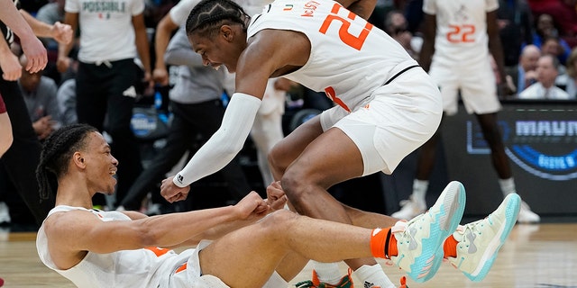 Cameron McGasty (23) congratulates Miami's Isaiah Wong after he shot and was fouled during the second half of a college basketball game in the Sweet 16 round of the NCAA tournament on Friday, March 25, 2022, in Chicago. 