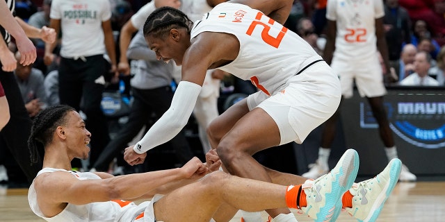 Miami's Isaiah Wong is conratulated by Kameron McGusty (23) after making a shot and being fouled during the second half of a college basketball game in the Sweet 16 round of the NCAA tournament Friday, 행진 25, 2022, 시카고에서.