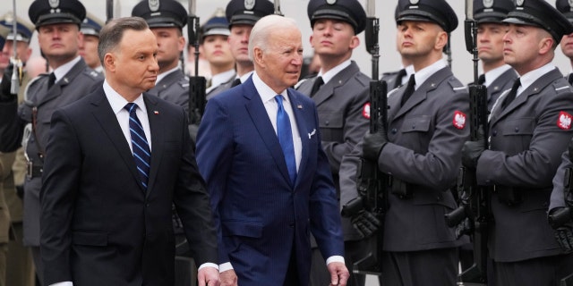 Prezydent Biden, centrum i prezydent Polski Andrzej Duda przechodzą obok gwardii honorowej podczas wojskowej ceremonii powitania w Pałacu Prezydenckim w Warszawie, sobota, 26 marca 2022 r.