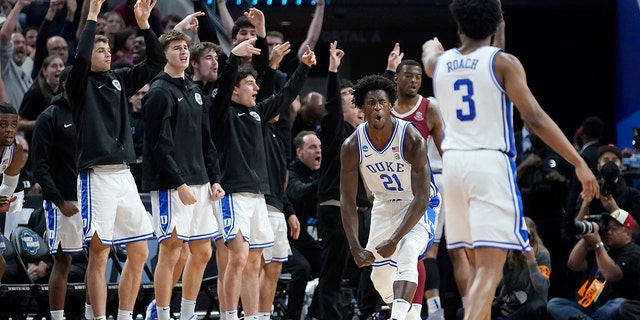 Duke forward AJ Griffin (21) celebrates in front of teammates on the bench after shooting a three point basket against Arkansas during the second half of a college basketball game in the Elite 8 round of the NCAA men's tournament in San Francisco, Saturday, March 26, 2022. (AP Photo/Marcio Jose Sanchez)