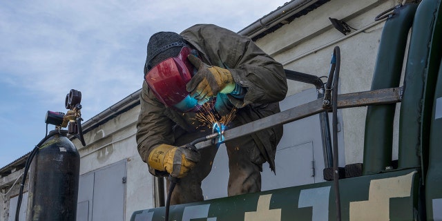 Car welder Ostap Datsenko, 31, works on a donated pickup truck so a volunteer can drive it to frontlines, at a welding workshop in Lviv, western Ukraine, Sunday, March 27, 2022.