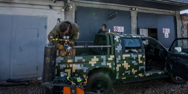 Car welder Ostap Datsenko, 31, works on a vehicle that will be sent to soldiers on the frontlines, at a welding workshop in Lviv, western Ukraine, Sunday, March 27, 2022.