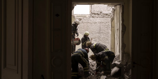 Emergency workers search for bodies under the debris of the regional administration building, heavily damaged after a Russian attack earlier this month in Kharkiv, Ukraine, Sunday, March 27, 2022.