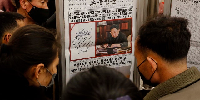 People look at a copy of North Korea 'newspaper Rodong Sinmun showing the report about the test-launch of a missile, at the Jonsung Station of Pyongyang Metro in Pyongyang, North Korea, on March 25, 2022.