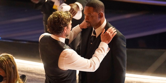 Bradley Cooper, left, and Will Smith appear in the audience at the Oscars on Sunday, March 27, 2022, at the Dolby Theatre in Los Angeles.