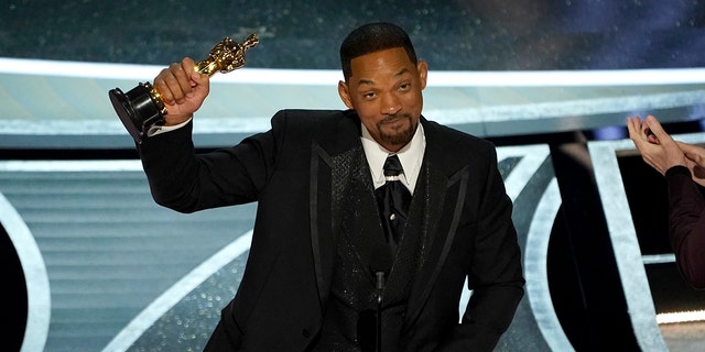 Will Smith accepts his Oscar for "King Richard" mere moments after he smacked comedian Chris Rock on stage. 