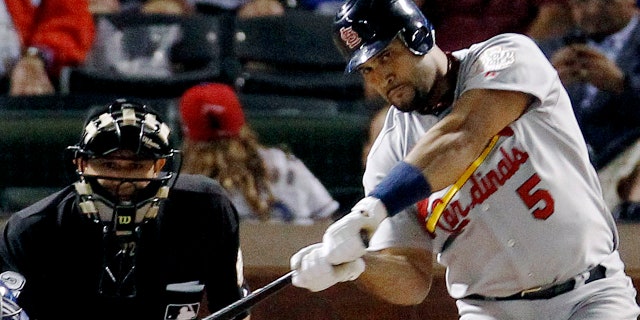 Albert Pujols of the St. Louis Cardinals hits a solo homer in the ninth inning of Game 3 of the World Series of Baseball against the Texas Rangers in Arlington, Texas, this Saturday, Oct. 22, 2011, file photo.