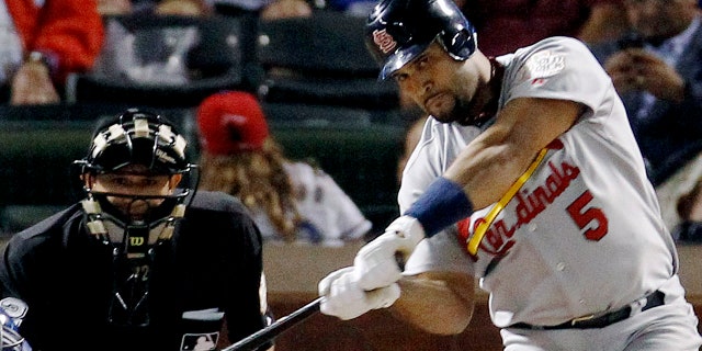 St. Louis Cardinals' Albert Pujols hits a solo home run during the ninth inning of Game 3 of baseball's World Series against the Texas Rangers in Arlington, Texas, in this Saturday, Oct. 22, 2011, file photo. 