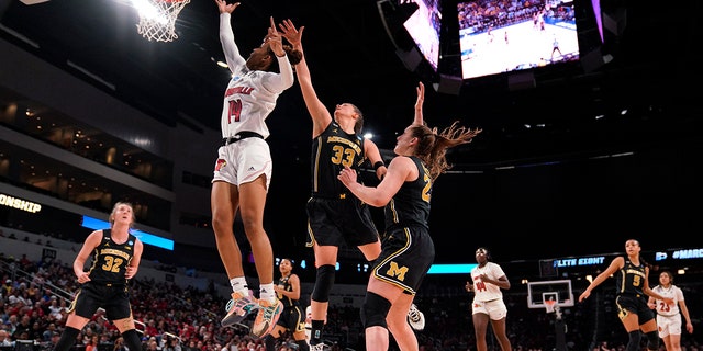 Louisville guard Kianna Smith (14) faces Michigan forward Emily Kiser (33) during the first half of a college basketball game in the Elite 8 round of the NCAA women's tournament on Monday, March 28, 2022 in Wichita, Kan.