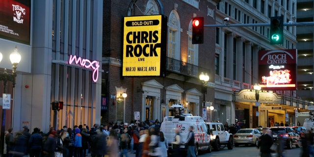 The marquee advertises Chris Rock as ticket holders wait to enter outside the Wilbur Theatre, Wednesday, March 30, 2022, in Boston. 
