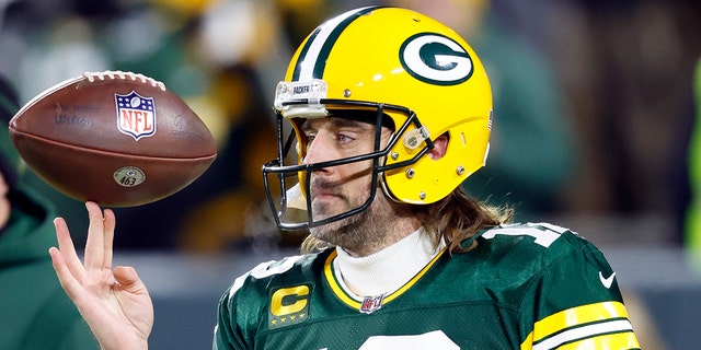 Le quart-arrière des Packers Aaron Rodgers fait tourner un ballon de football avant le match éliminatoire de la division contre les 49ers de San Francisco le 22 janvier 2022, à Green Bay, Wisconsin.