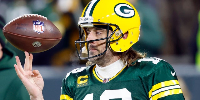 Le quart-arrière des Packers Aaron Rodgers fait tourner un ballon de football avant le match éliminatoire de la division contre les 49ers de San Francisco le 22 janvier 2022, à Green Bay, Wisconsin.