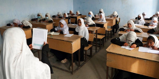FILE: Afghan girls students attend school classes in a primary school in Kabul, Afghanistan, Saturday, March 27, 2021. 