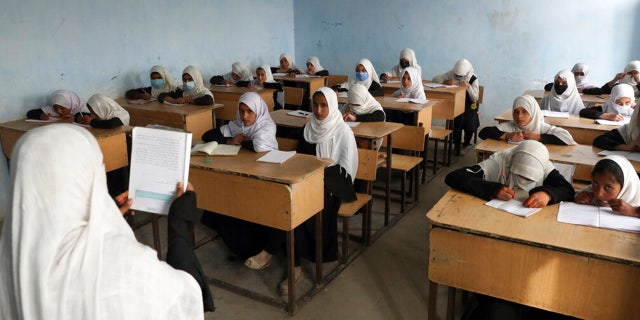 FILE: Afghan girls students attend school classes in a primary school in Kabul, Afghanistan, Saturday, March 27, 2021.