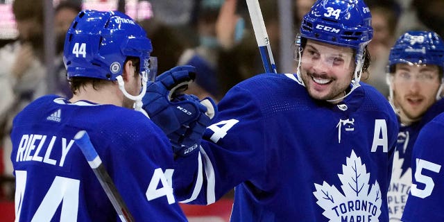 Toronto Maple Leafs forward Auston Matthews (34) celebrates his hat trick with teammate Morgan Rielly (44) during the third period of an NHL hockey game against the Seattle Kraken, Tuesday, March 8, 2022, in Toronto.
