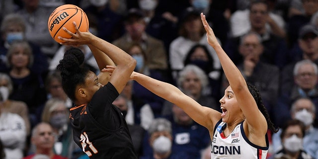 Mercer's Shannon Titus, left, shoots as Connecticut's Azzi Fudd, right, during the first half of a first-round women's college basketball game in the NCAA tournament, Saturday, March 19, 2022, in Storrs, Conn.