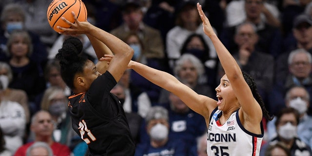 Mercer's Shannon Titus, left, shoots as Connecticut's Azzi Fudd, right, during the first half of a first-round women's college basketball game in the NCAA tournament, Saturday, March 19, 2022, in Storrs, Conn.