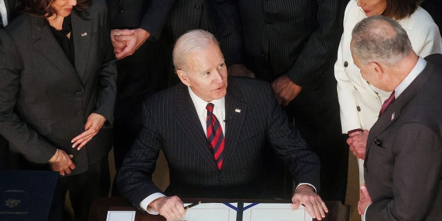 President Biden is flanked by Vice President Kamala Harris, House Speaker Nancy Pelosi and Senate Majority Leader Chuck Schumer as he signs the Consolidated Appropriations Act at the White House, March 15, 2022.