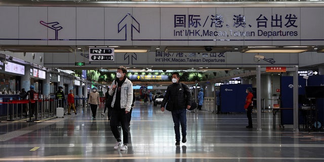 Travellers walk at a terminal hall of the Beijing Capital International Airport in Beijing, China March 23, 2022.