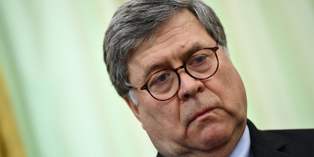 Attorney General Bill Barr waits before President Trump signs an executive order about social media in the Oval Office of the White House on May, 28, 2020, in Washington, D.C.