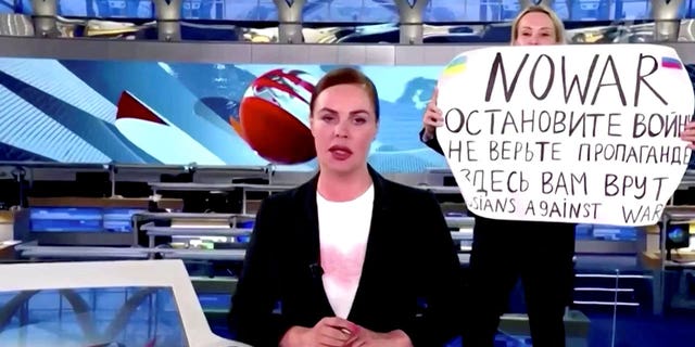 玛丽娜·奥夫扬尼科娃（Marina Ovsyannikova）打断了俄罗斯国家电视台“第一频道”的新闻直播，举着一个标语，上面写着“不要战争。停止战争。不要相信宣传。他们在这里对你撒谎。”  2022 年 3 月 14 日在俄罗斯的一个未知地点，这张静止图像是从 3 月 14 日上传的视频中获得的。