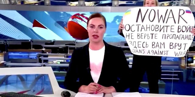 Marina Ovsyannikova  interrupts a live news bulletin on Russia's state TV "Channel One" with a sign that reads "NO WAR. Stop the war. Don't believe propaganda. They are lying to you here" on March 14, 2022.