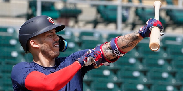 The Minnesota Twins' Carlos Correa adjusts his arm protector during batting practice at Hammond Stadium March 23, 2022, in Fort Myers, Fla. 