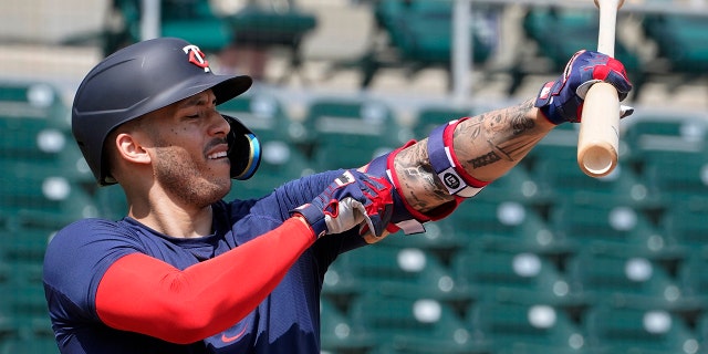 Minnesota Twins' Carlos Correa adjusts his arm protector during batting practice at Hammond Stadium Wednesday March 23, 2022, in Fort Myers, Fla.