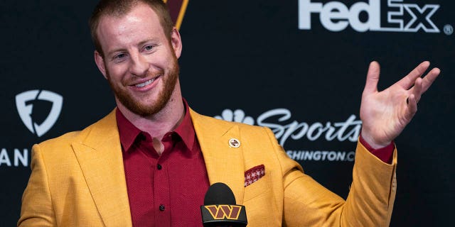 Washington Commanders NFL football team new quarterback Carson Wentz greets members of the media after being introduced by head coach Ron Rivera, a during a news conference in Ashburn, Va., Thursday, March 17, 2022.