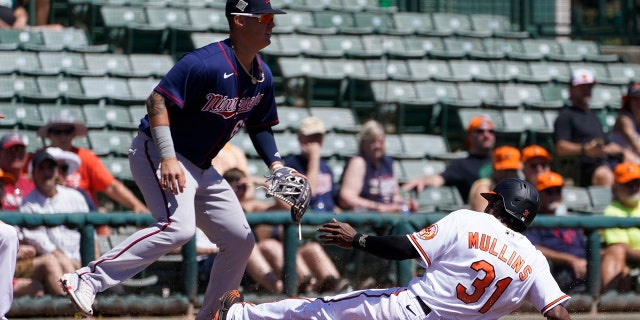 Baltimore Orioles' Cedric Mullins (31) slides into third base as Minnesota Twins third baseman Jose Miranda, left, waits for the throw in the second inning of a spring training baseball game Monday, March 21, 2022, in Sarasota, Fla.