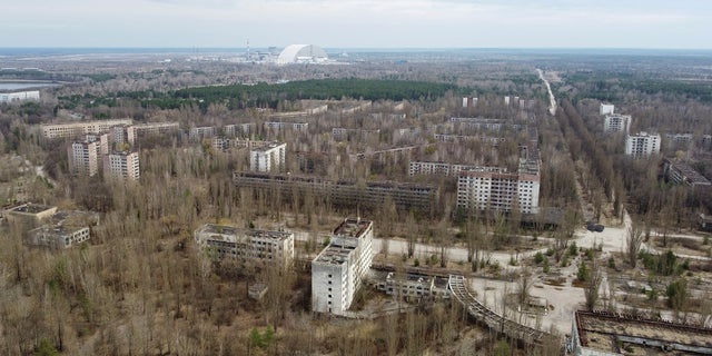 A New Safe Confinement (NSC) structure over the old sarcophagus covering the damaged fourth reactor at the Chernobyl Nuclear Power Plant is seen behind the abandoned town of Pripyat, Ukraine. Workers at the plant said Russian soldiers disturbed radioactive dust and failed to wear protective gear after taking control of the site.