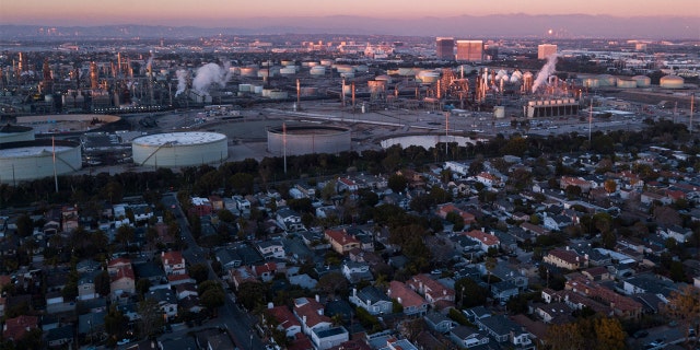 An aerial image taken on Jan. 24, 2022, shows storage tanks at the Chevron Products Company El Segundo Refinery adjacent to homes at sunset in Manhattan Beach, California.
