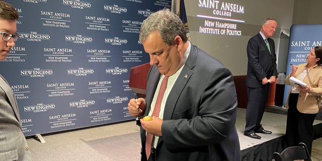 Former New Jersey Governor Chris Christie signs the iconic wooden eggs after speaking at “Politics and Eggs” at the New Hampshire Institute of Politics at Saint Anselm College, March 21, 2022 in Goffstown, NH