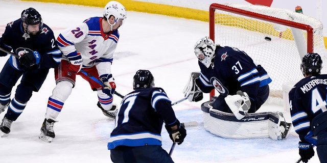 New York Rangers' Chris Kreider (20) scores against Winnipeg Jets goaltender Connor Hellebuyck (37) during the first period of NHL hockey game action in Winnipeg, 매니토바, 일요일, 행진 6, 2022.