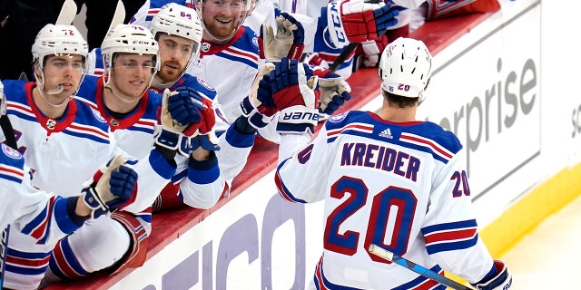 New York Rangers' Chris Kreider (20) returns to the bench after scoring during the third period of an NHL hockey game against the Pittsburgh Penguins in Pittsburgh, Tuesday, March 29, 2022. The Rangers won 3-2.