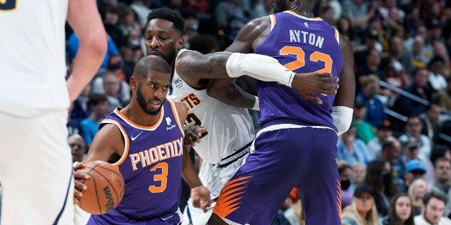 Phoenix Suns guard Chris Paul, left, drives past Denver Nuggets forward Jeff Green, center, who is screened by Suns center Deandre Ayton during the second half of an NBA basketball game Thursday, March 24, 2022, in Denver.