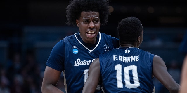 Saint Peter's Peacocks forwards Clarence Rupert and Fousseyni Drame (10) celebrate on the court during the NCAA Division I Men's Basketball Championship Round 2 game against the Murray State Racers on March 19, 2022, at Gainbridge Fieldhouse in Indianapolis, Indiana.