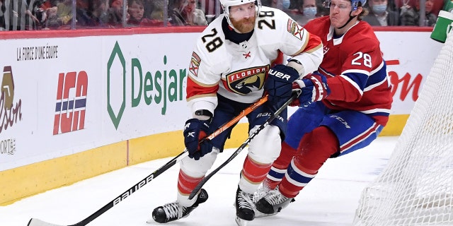 Claude Giroux #28 of the Florida Panthers looks to pass the puck against Christian Dvorak #28 of the Montreal Canadiens in the NHL game at the Bell Centre on March 24, 2022 in Montreal, 魁北克, 加拿大.