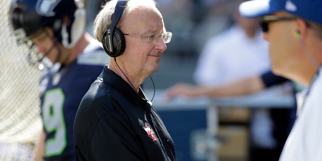 FILE - John "The Professor" Clayton, an NFL football writer and reporter for ESPN, stands on the sideline during an NFL football game between the Seattle Seahawks and the San Francisco 49ers, Sunday, Sept. 25, 2016, in Seattle. Clayton died Friday, March 18, 2022, following a short illness. He was 67.
